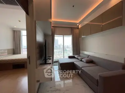 Modern living room with city view, featuring sleek furniture and elegant lighting, adjacent to a cozy bedroom.