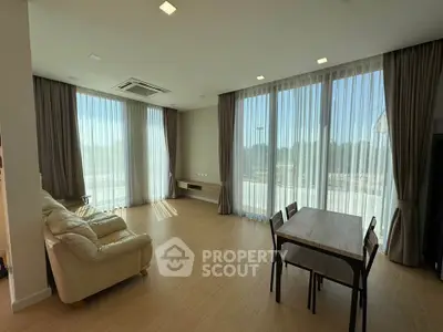 Spacious living room with large windows and elegant curtains