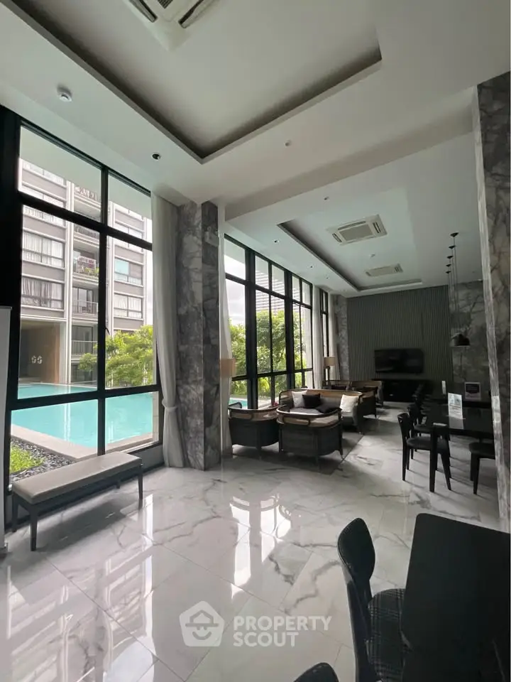 Luxurious poolside lounge with modern seating and large windows in upscale residential building.