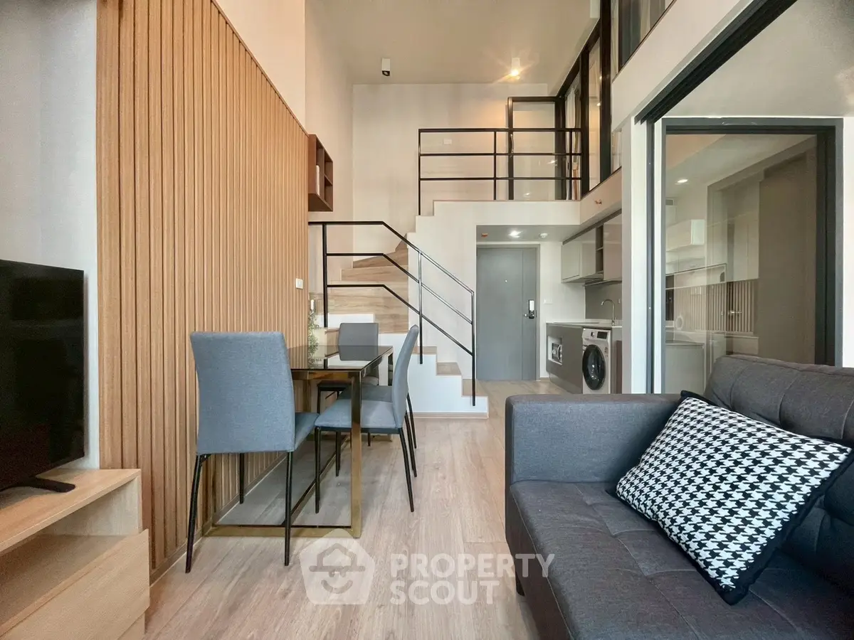Modern duplex apartment with stylish interior, featuring open living area, dining space, and sleek kitchen.