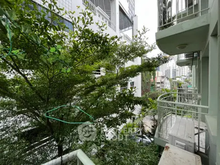Charming urban balcony with lush greenery and city views, perfect for relaxation and enjoying nature.