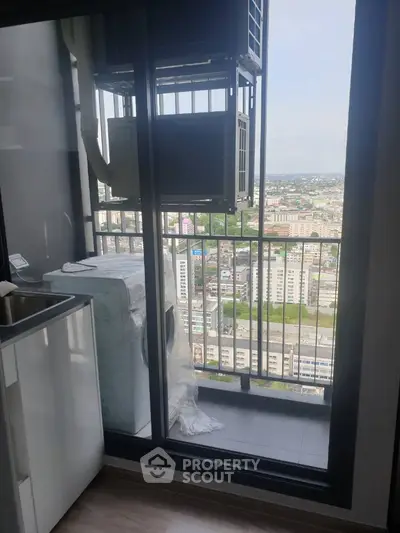 High-rise apartment balcony with city view and washing machine