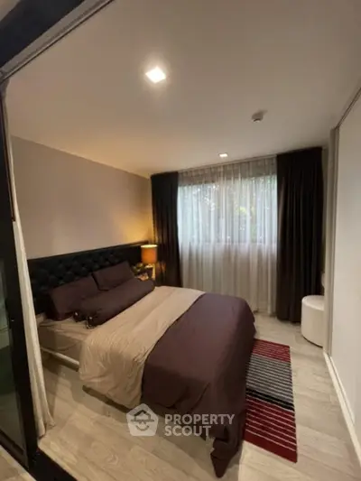 Cozy bedroom with modern decor and large window for natural light