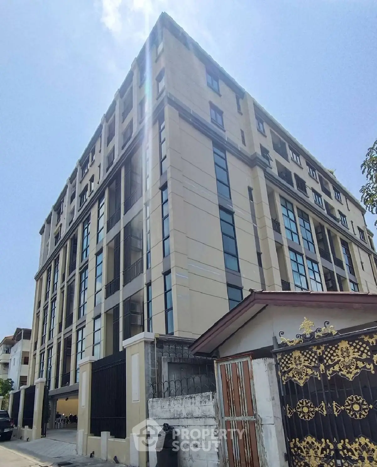 Modern multi-story building with large windows and elegant facade in urban setting.