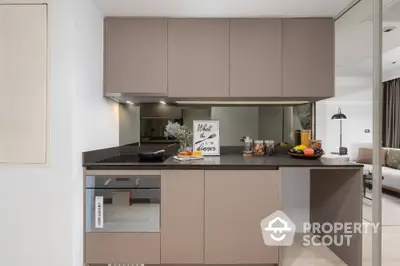 Modern kitchen with sleek cabinetry and built-in oven in stylish apartment