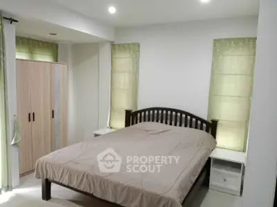 Cozy bedroom with modern decor and ample natural light, featuring a comfortable bed and stylish wardrobe.