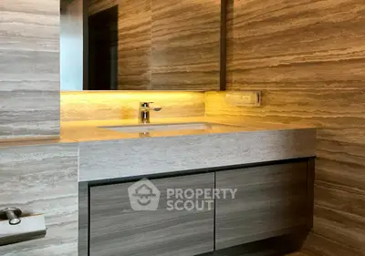 Luxurious bathroom with modern sink and elegant stone wall design.