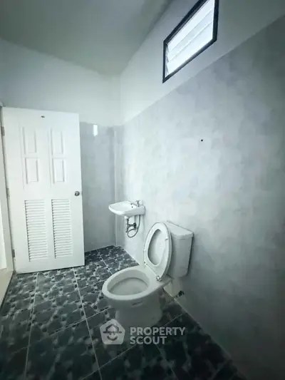 Spacious bathroom with modern fixtures and tiled flooring in a bright setting.