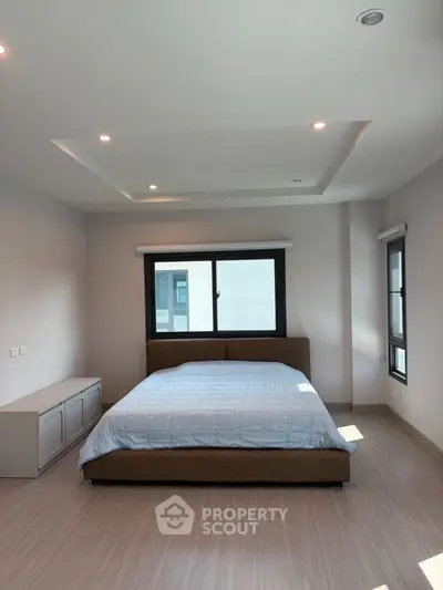 Spacious bedroom with modern design and large windows for natural light.