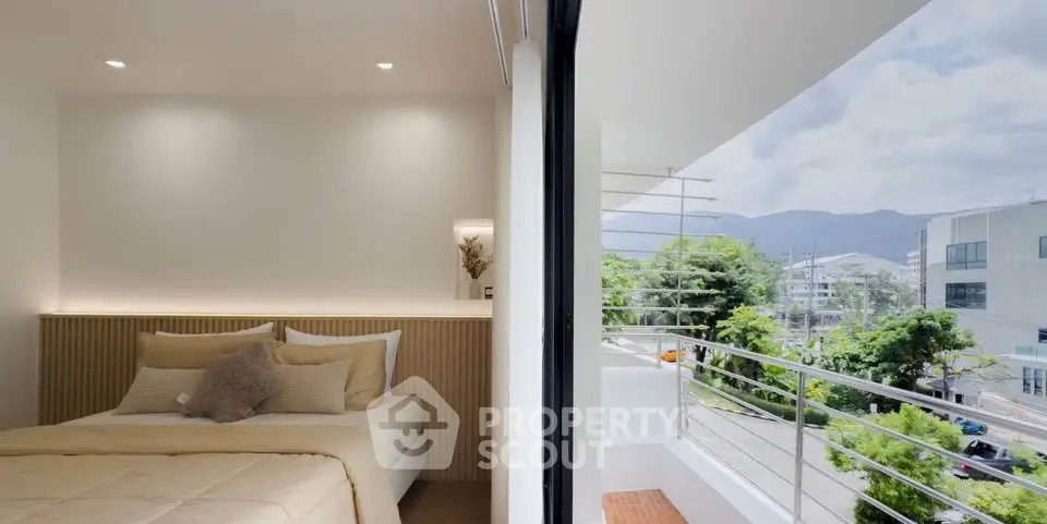 Modern bedroom with balcony offering scenic city and mountain views