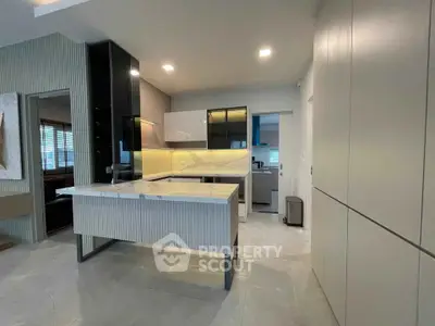 Modern kitchen with sleek cabinetry and open layout, featuring a stylish island and contemporary lighting.