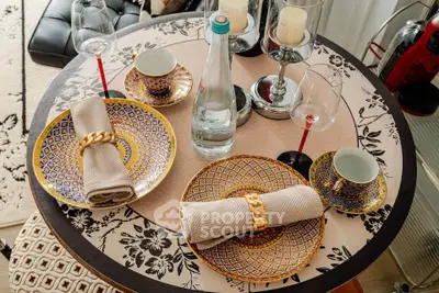 Elegant dining table setup with ornate plates and glassware in a cozy living space.