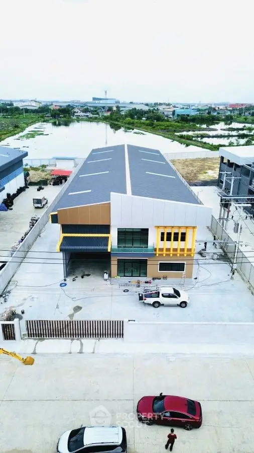 Modern industrial building with spacious parking and scenic water view