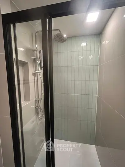 Modern bathroom shower with sleek glass door and contemporary tile design.