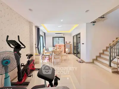 Spacious modern living room with exercise equipment and dining area