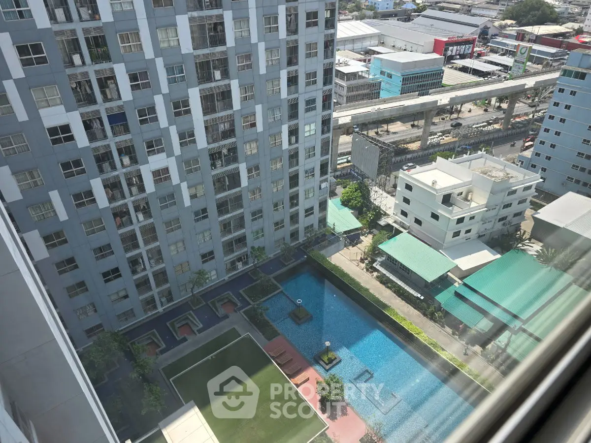 High-rise building with pool and garden view from upper floor, showcasing urban living amenities.