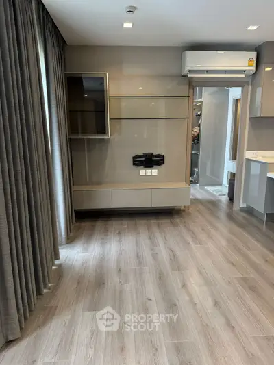 Modern living room with sleek flooring and built-in TV mount, perfect for contemporary living.