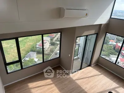 Spacious corner unit with large windows offering panoramic city views, featuring modern air conditioning.