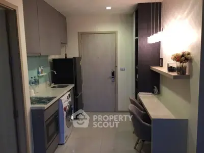Modern kitchen with washing machine and sleek cabinetry in compact apartment