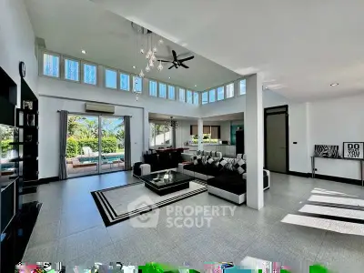 Spacious modern living room with high ceilings and pool view, perfect for luxury living.