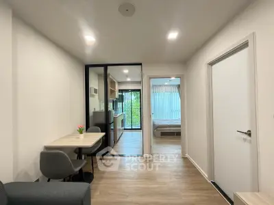 Modern apartment interior with open layout, featuring a cozy dining area and view into a bedroom.