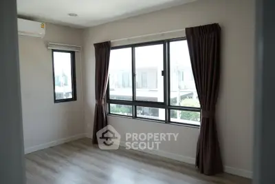 Spacious empty room with large windows and elegant curtains, perfect for customization.