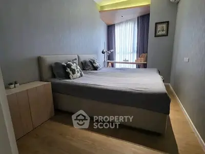 Modern bedroom with stylish decor and natural light, featuring a comfortable bed and elegant furnishings.