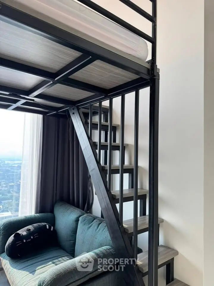 Modern loft apartment with stylish metal staircase and cozy seating area, offering a panoramic city view.