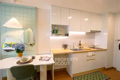 Charming modern kitchen with sleek cabinetry and cozy dining area, perfect for urban living.