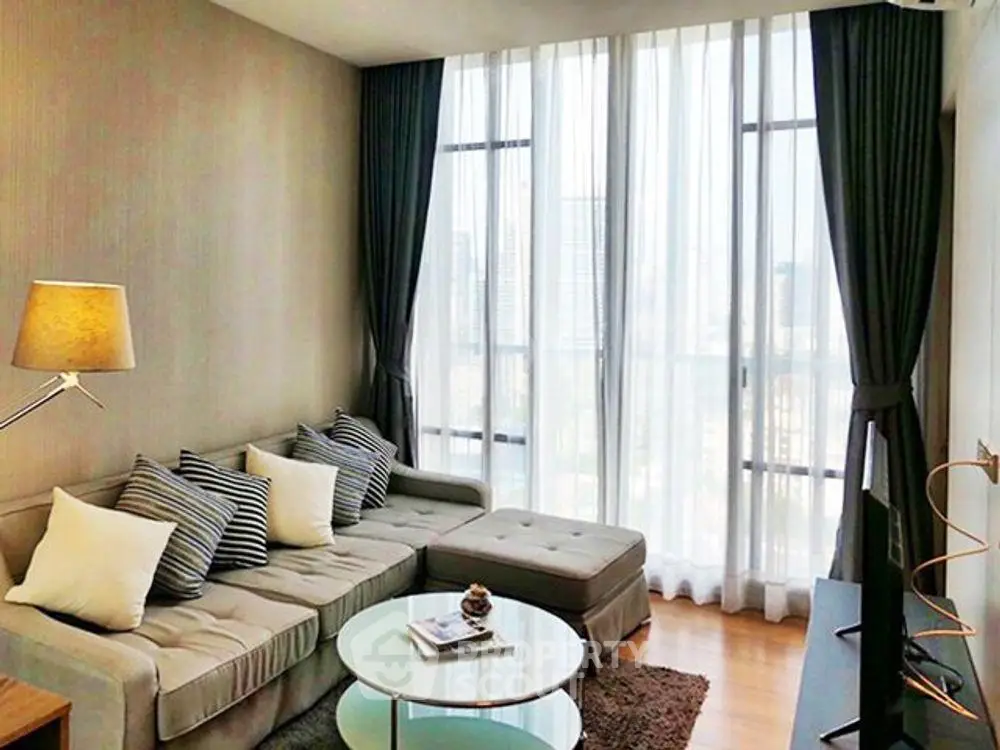 Modern living room with floor-to-ceiling windows and stylish decor in urban apartment.