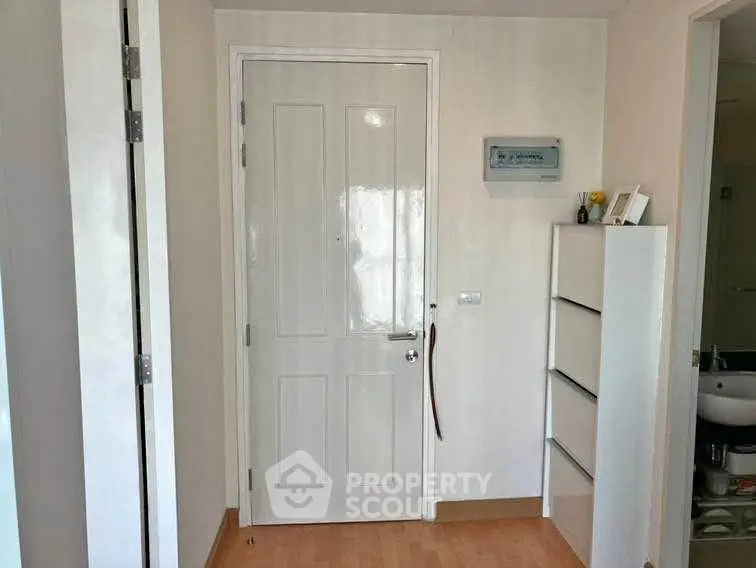 Modern apartment entrance with sleek white door and minimalist decor