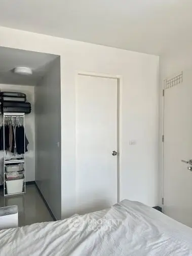 Bright and airy bedroom with a spacious built-in wardrobe, showcasing a minimalist design with a clean white palette, perfect for restful living.