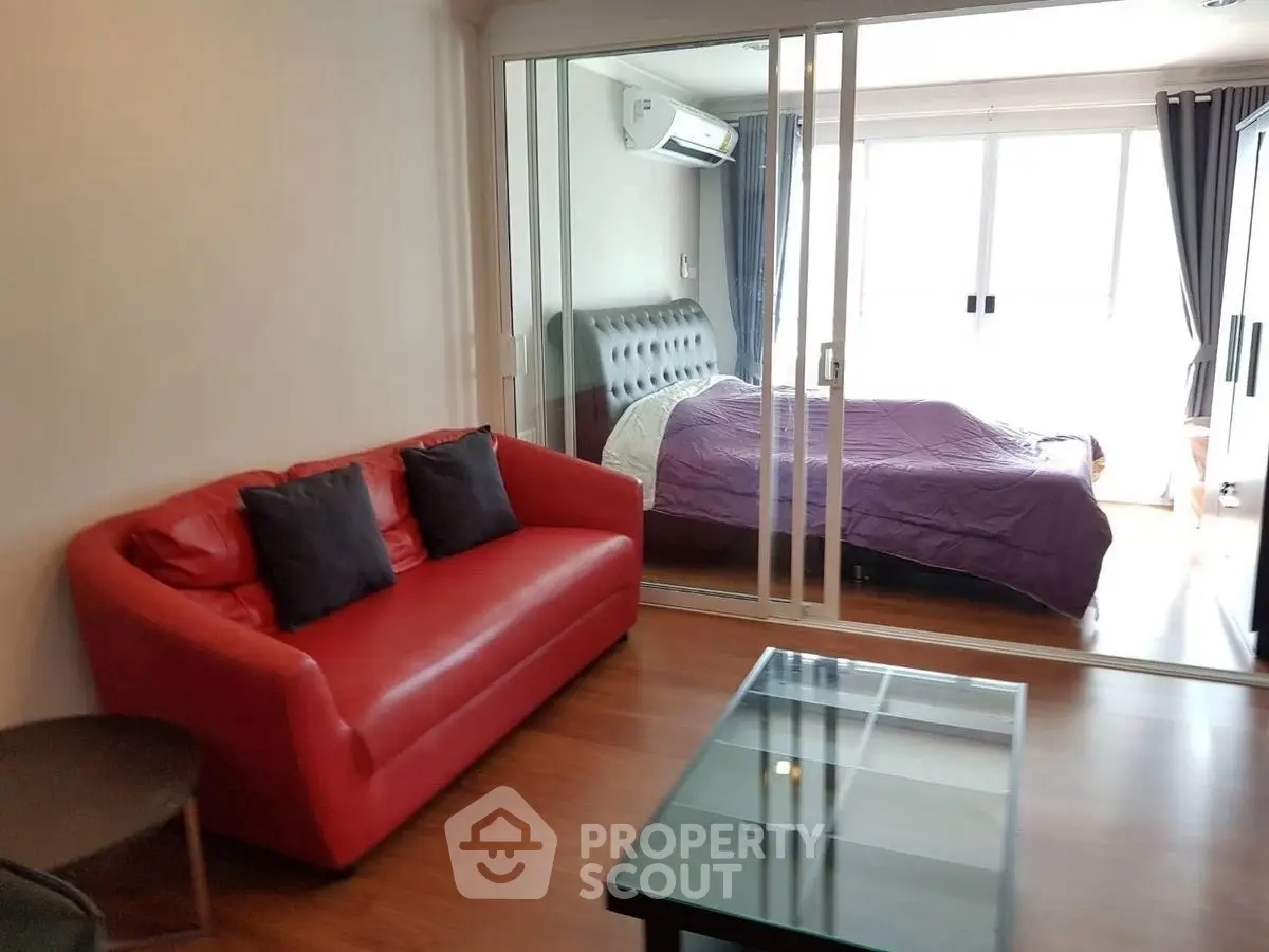 Modern apartment with red sofa and glass coffee table in cozy living area.