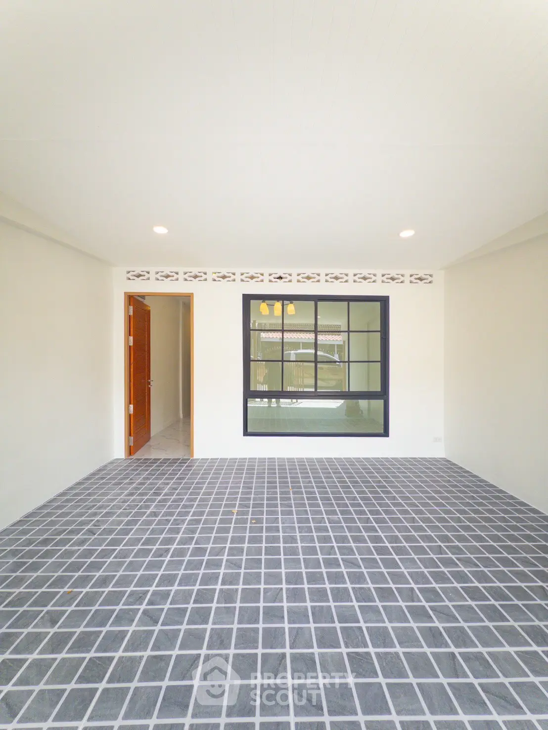 Spacious room with tiled floor and large window, perfect for versatile use.