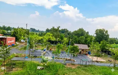 Expansive green landscape with trees and small structures, ideal for development or leisure.