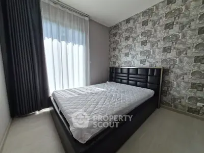 Modern bedroom with stylish wallpaper and large window, featuring a comfortable bed and elegant curtains.
