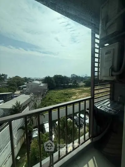 Charming balcony with scenic view of lush greenery and urban landscape, perfect for relaxation.