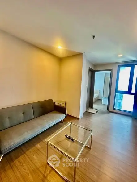Modern living room with sleek furniture and wooden flooring in a cozy apartment.