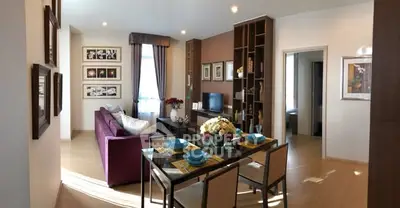 Stylish living room with modern decor and dining area in open layout apartment.