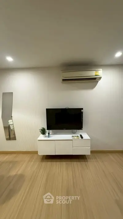 Modern living room with wall-mounted TV and air conditioning unit