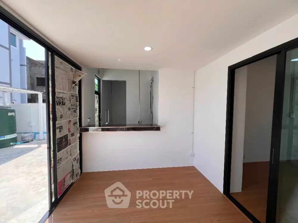 Modern interior with large windows and wooden flooring, ideal for a bright and airy living space.
