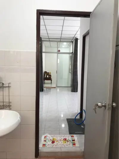 Spacious tiled hallway with modern bathroom entrance, showcasing sleek design and functional layout.