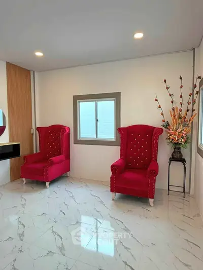 Elegant interior with red armchairs and marble flooring, perfect for a stylish living room or lounge area.