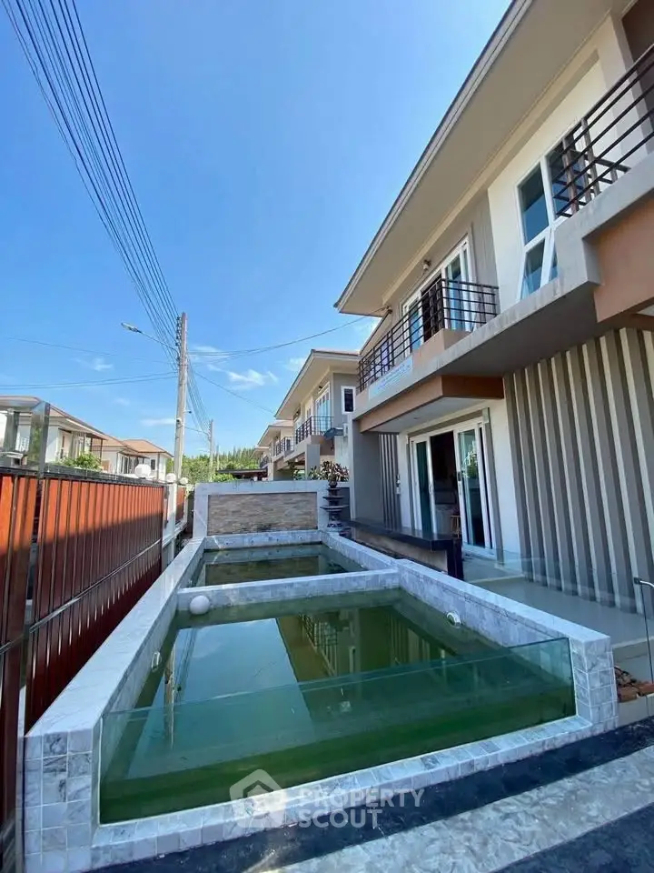 Modern townhouse with sleek exterior and private pool in a serene neighborhood.