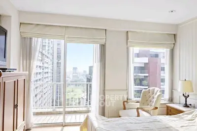 Bright bedroom with city view and balcony access in modern apartment.