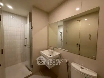 Modern bathroom with glass shower and sleek fixtures in a contemporary apartment.