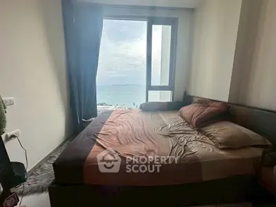 Cozy bedroom with ocean view and large window, perfect for relaxation and enjoying the scenery.