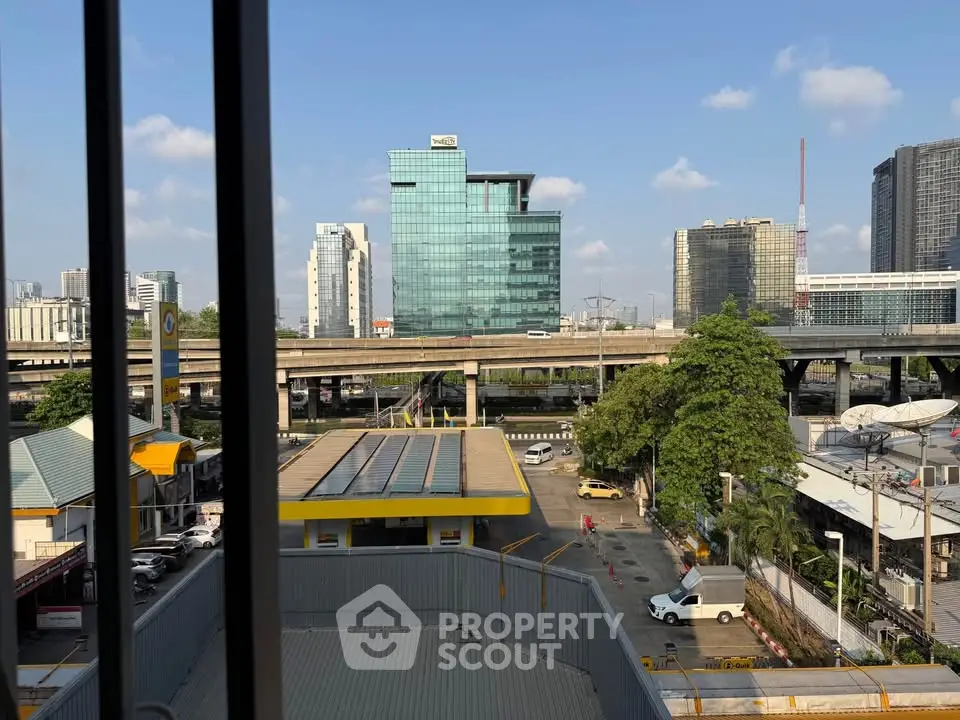 Urban cityscape view from a high-rise building window, showcasing modern architecture and a bustling city environment.