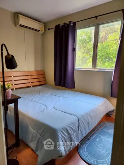 Cozy bedroom with large window and natural light, featuring a comfortable bed and stylish decor.