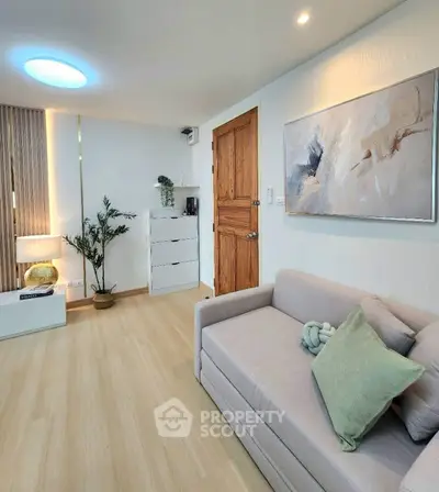 Modern living room with cozy sofa, stylish decor, and wooden flooring